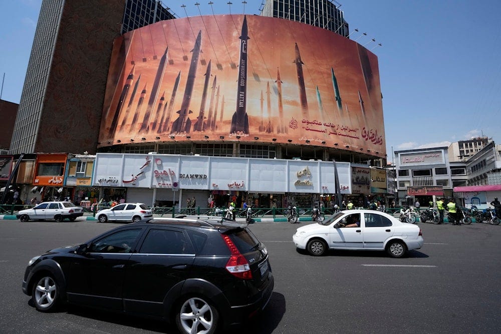 Vehicles drive past an anti-Israeli banner showing missiles being launched, in a square in downtown Tehran, Iran, Friday, April 19, 2024. (AP) Vehicles drive past an anti-Israeli banner showing missiles being launched, in a square in downtown Tehran, Iran, Friday, April 19, 2024. (AP)