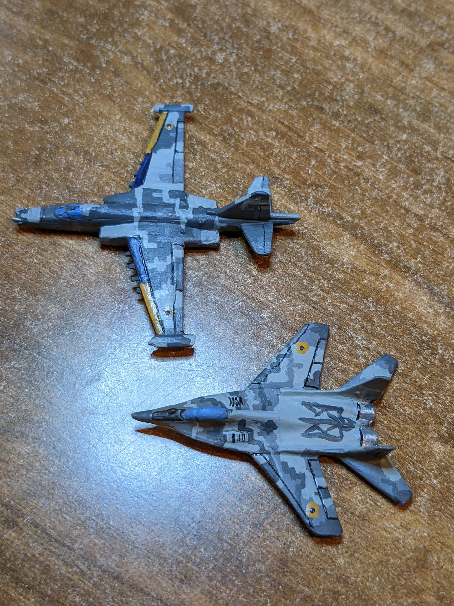 2 x 6 mm scale models, one a SU-25 ground attack fighter and the other a MIG 29.  They are both painted in grey digital camo of the Ukrainian Airforce