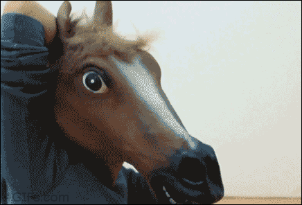 A person in a horse mask removes the mask to reveal another horse mask