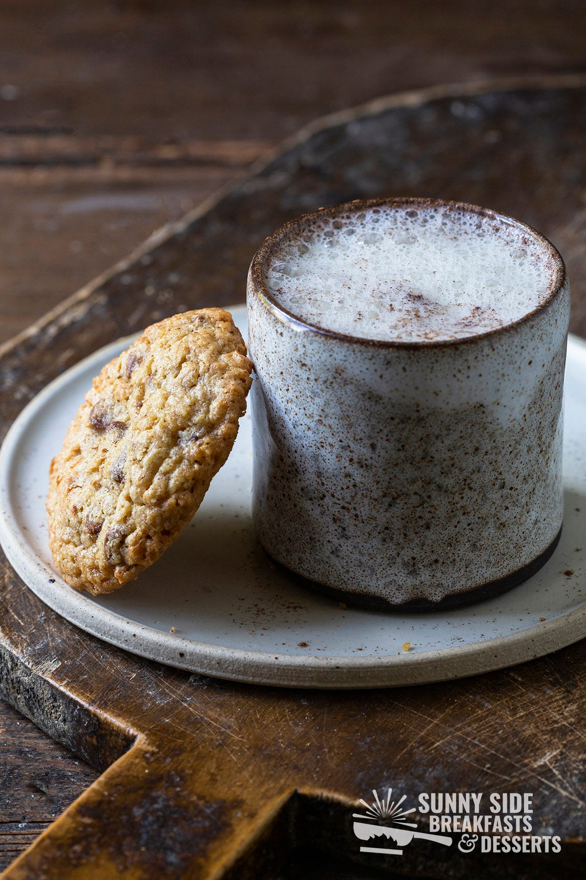 A mug of moon milk with a cookie.