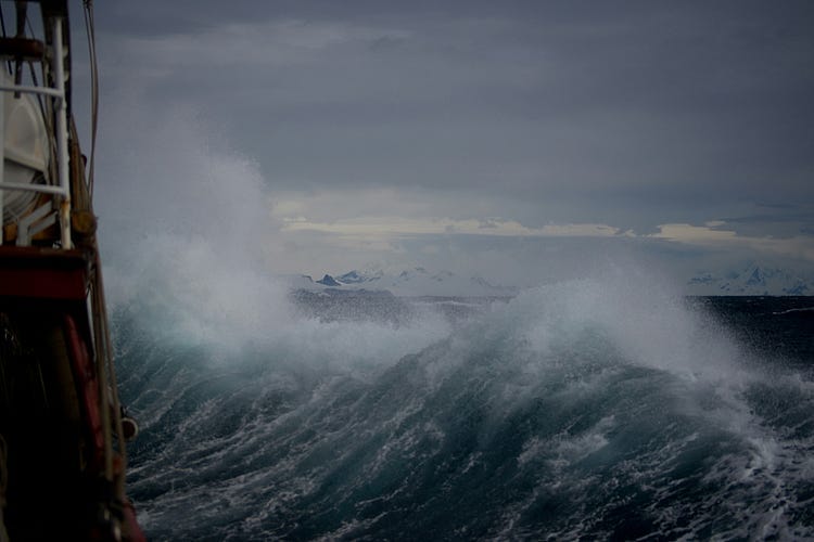 Ship sailing in rough waves at sea.