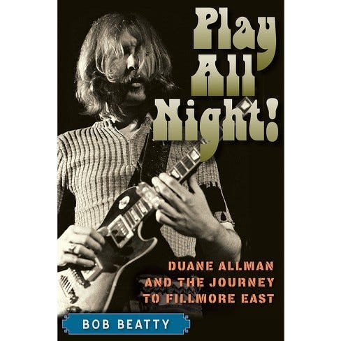 Cover of Play All Night! Duane Allman and the Journey to Fillmore East. Duane has his eyes closed, shoulder-length hair in front of his face as he plays slide at the 14th fret with a Coricidin bottle on his left ring finger. He plays without a pick, the strings on his Gibson Les Paul are top-wrapped, and his pickup selector in the Treble (down) position. He is wearing a short-sleeved ribbed sweater with a zipper at the neck, a ring on his right ring finger, and jeans with a belt.