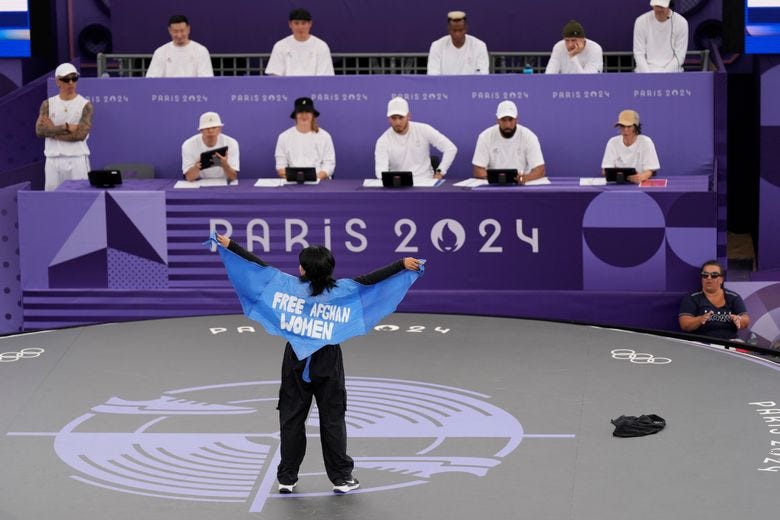 Refugee Team&#8217;s Manizha Talash, known as Talash, wears a cape which reads &#8220;free Afghan women&#8221; as she competes during the B-Girls Pre-Qualifier Battle at the breaking competition at La Concorde Urban Park at the 2024 Summer Olympics, Friday, Aug. 9, 2024, in Paris, France. (AP Photo/Abbie Parr)