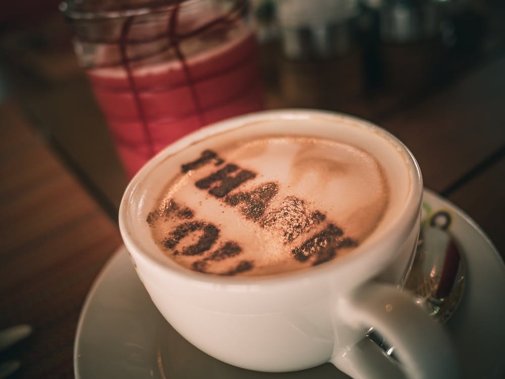 Free Cup of aromatic cappuccino with Thank You words on foam Stock Photo