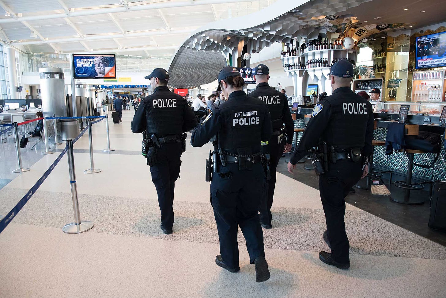 Police walking through airport terminal.