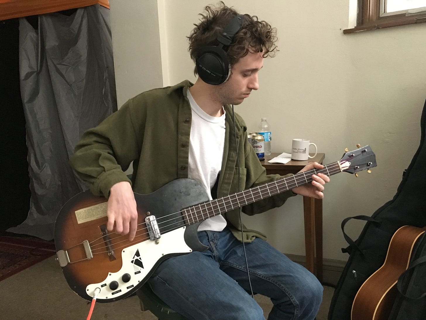Henry playing a bass guitar in the studio in 2018 or 2019.