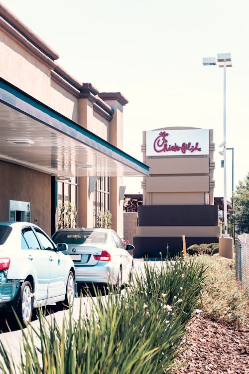 Free Vehicles in a drive-thru line outside a busy fast food restaurant during the day. Stock Photo