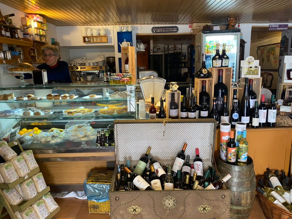 A shop full of wine, a counter and produce