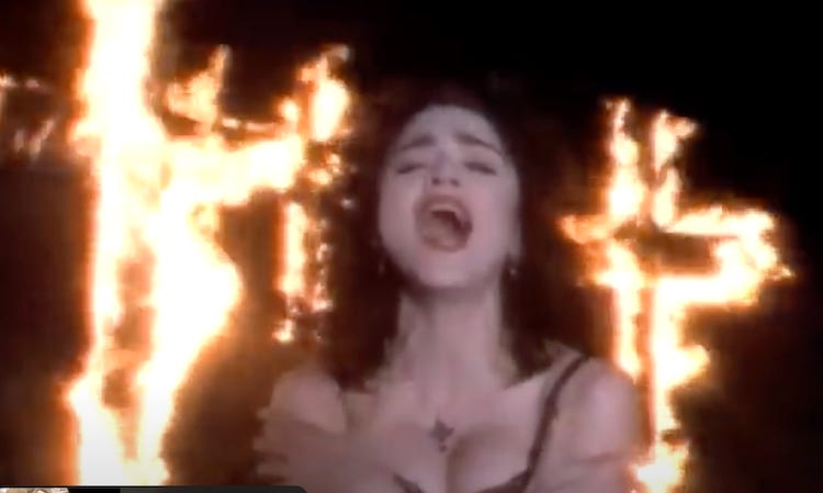 Madonna sings in front of burning crosses