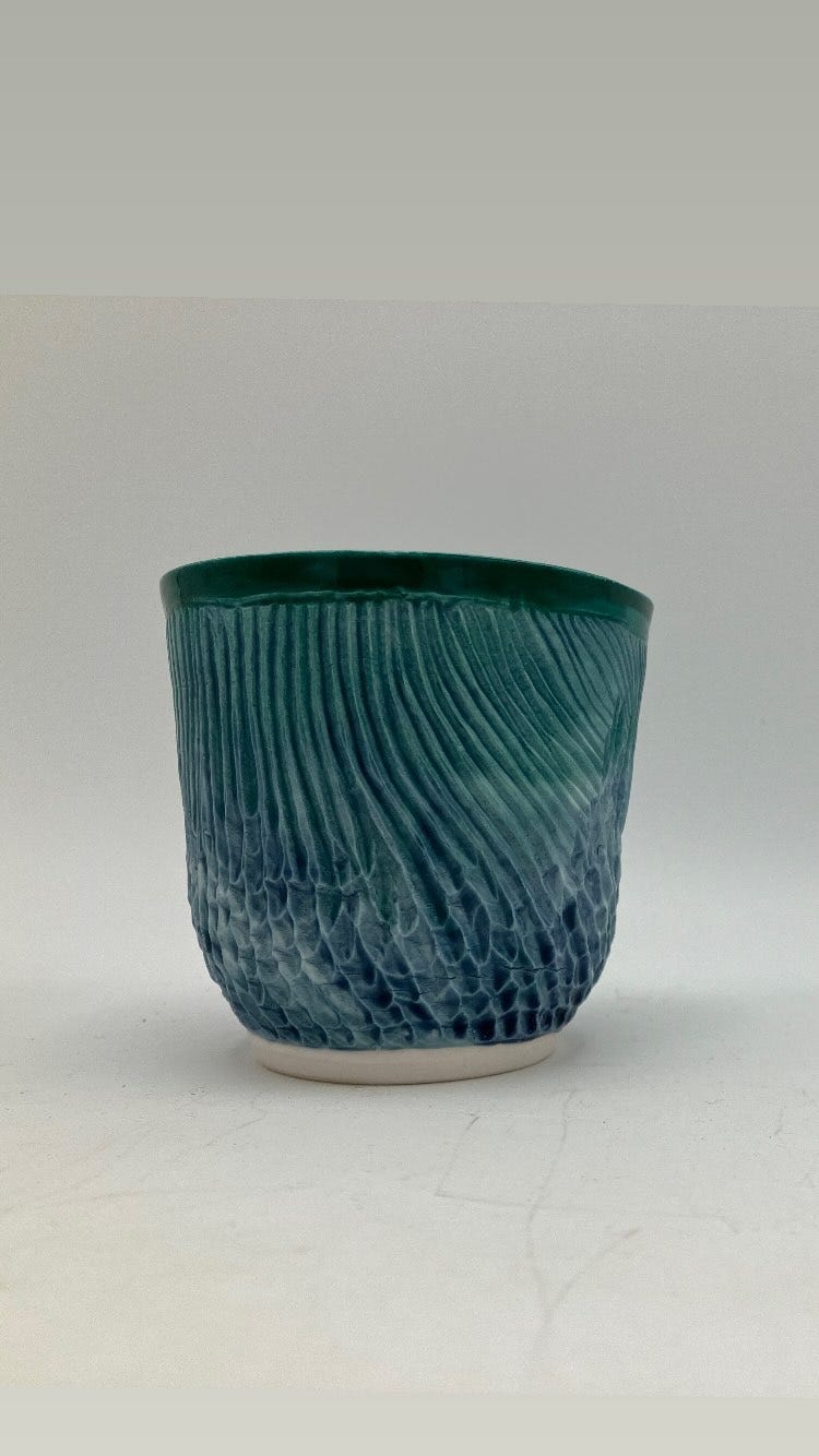 blue-green porcelain cup carved; photo taken in lightbox with white background