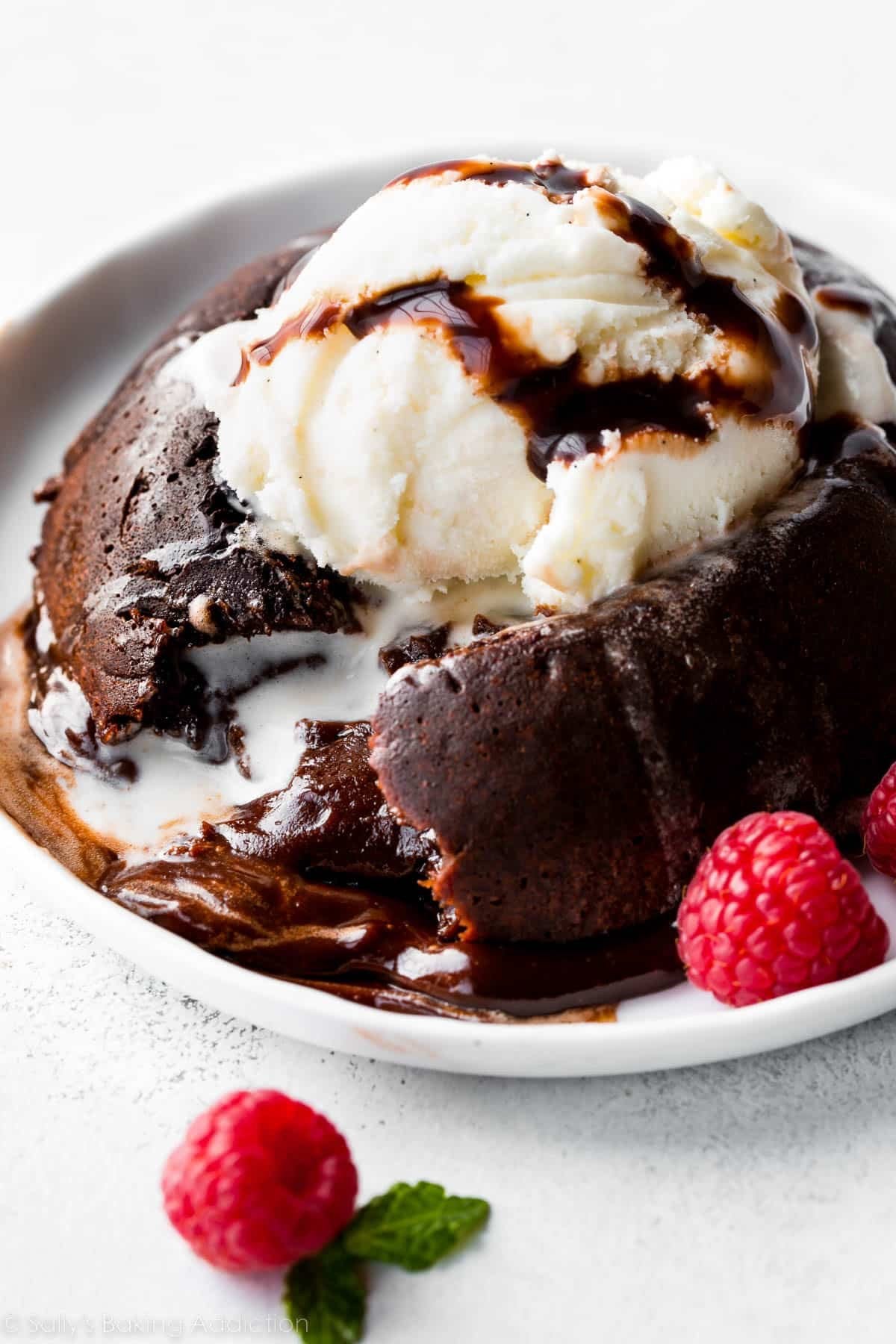 chocolate lava cake with a scoop of vanilla ice cream on a white plate.