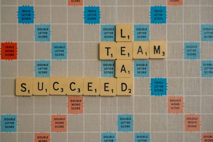 scrabble board featuring the words: lead, team, succeed