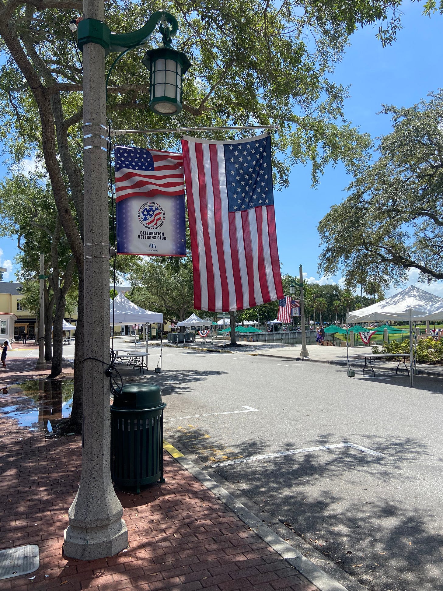 Two American flags on a lampost.