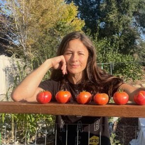 me standing with a few red tomatoes from the garden