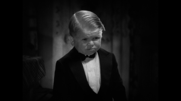 Harry Earles, a little person dressed in a tuxedo, appearing as Hans in Freaks
