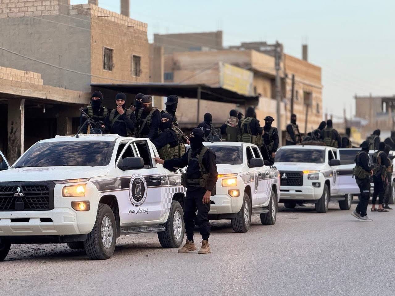 A group of people in black uniforms standing on a white truck

AI-generated content may be incorrect.