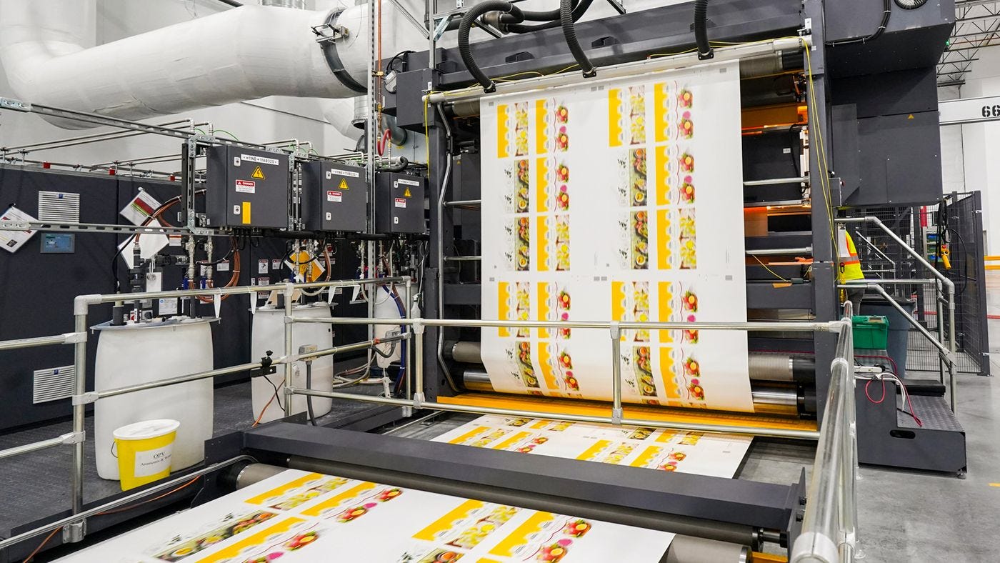 Rolls of paper being printed on industrial machinery.