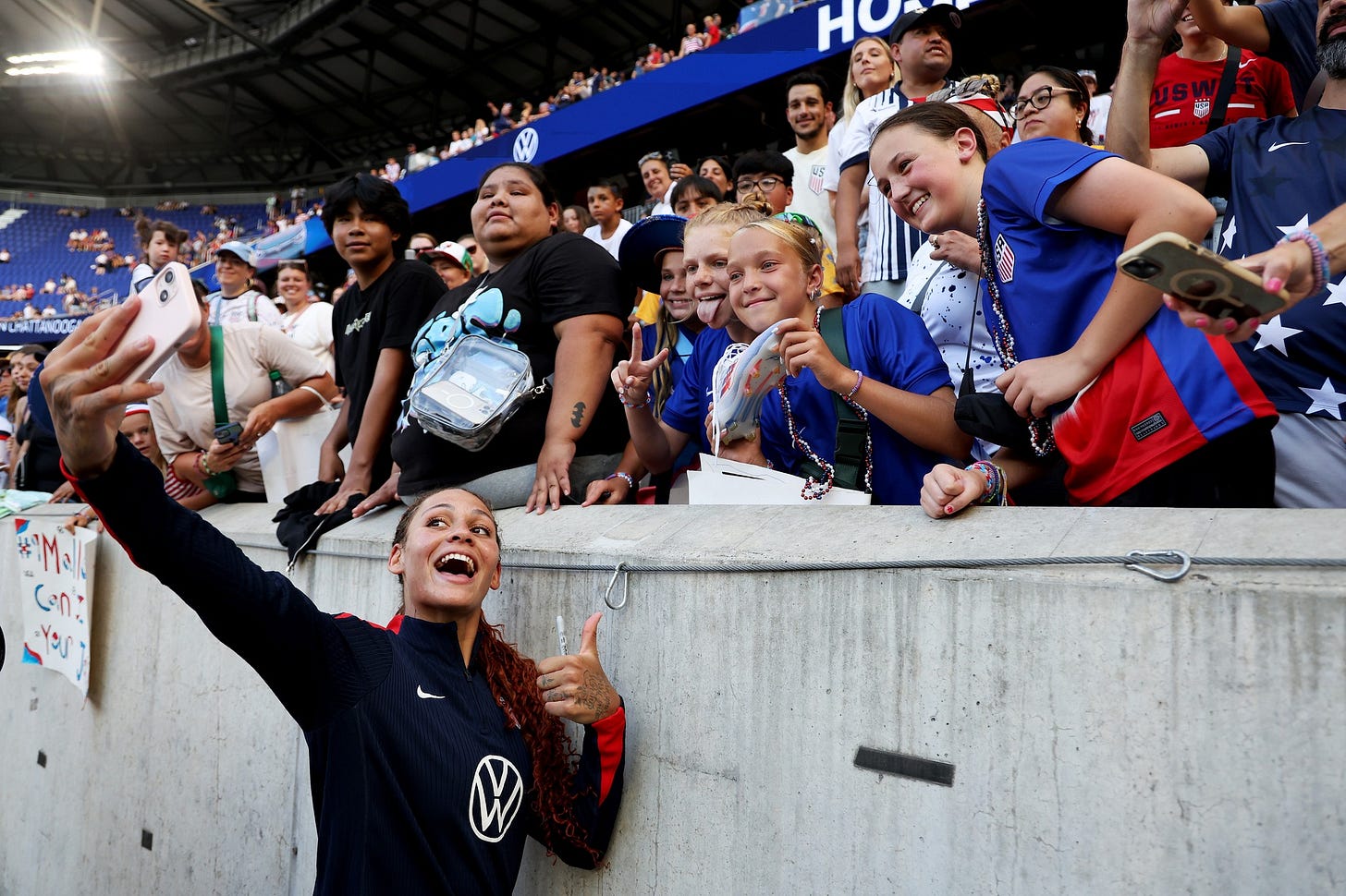 May be an image of 3 people, people playing football, people playing soccer, crowd and text