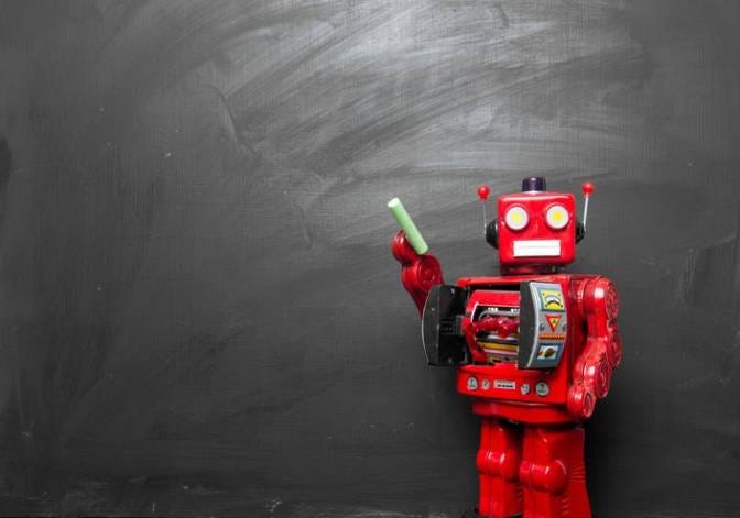 Robot teacher with chalk next to chalkboard