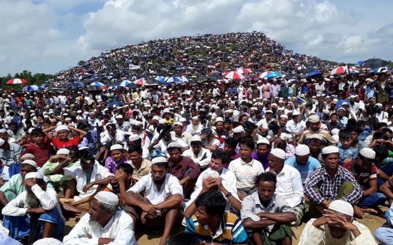 A large group of people sitting on a hill

Description automatically generated