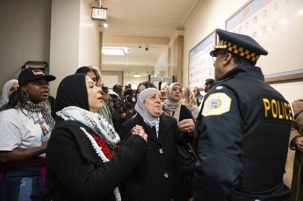 Supporters of the cease-fire resolution react to a police officer telling them that they would not be let back into the council chambers after it was cleared during a City Council meeting to discuss a resolution that would call for a cease-fire in Gaza, Wednesday, Jan. 31, 2024, in Chicago. Chicago’s City Council narrowly approved a resolution Wednesday calling for a permanent cease-fire in the war between Israel and Hamas with Mayor Brandon Johnson casting the tiebreaking vote. (Pat Nabong/Chicago Sun-Times via AP) Supporters of the cease-fire resolution react to a police officer telling them that they would not be let back into the council chambers after it was cleared during a City Council meeting to discuss a resolution that would call for a cease-fire in Gaza, Wednesday, Jan. 31, 2024, in Chicago. Chicago’s City Council narrowly approved a resolution Wednesday calling for a permanent cease-fire in the war between Israel and Hamas with Mayor Brandon Johnson casting the tiebreaking vote. (Pat Nabong/Chicago Sun-Times via AP)