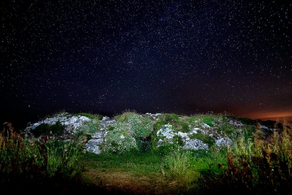 star-filled night sky over ancient ruin