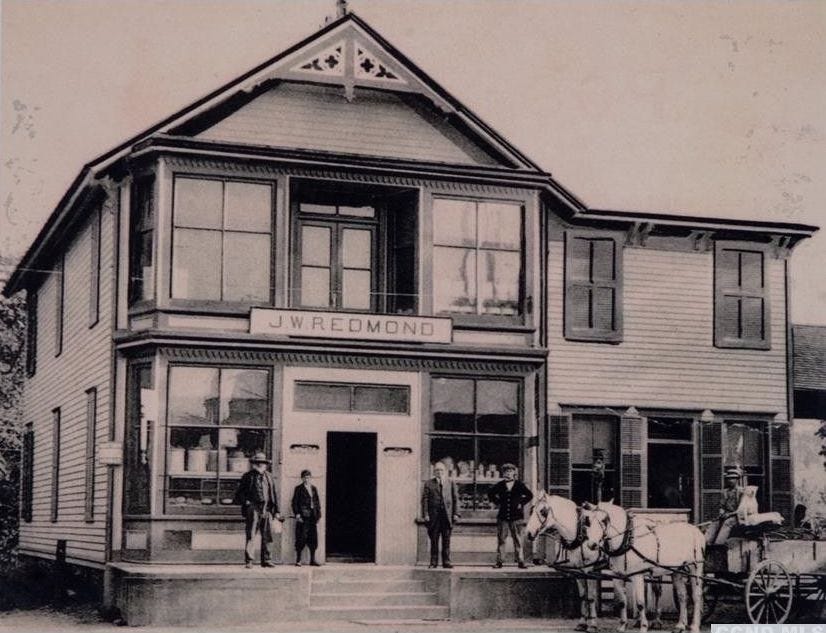 Old Chatham Country Store, possibly pre 1800 with four men and two beautiful white draft horses hitched to a wagon.