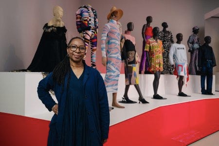 La curatrice de l'exposition Africa Fashion devant quelques unes des pièces exposées