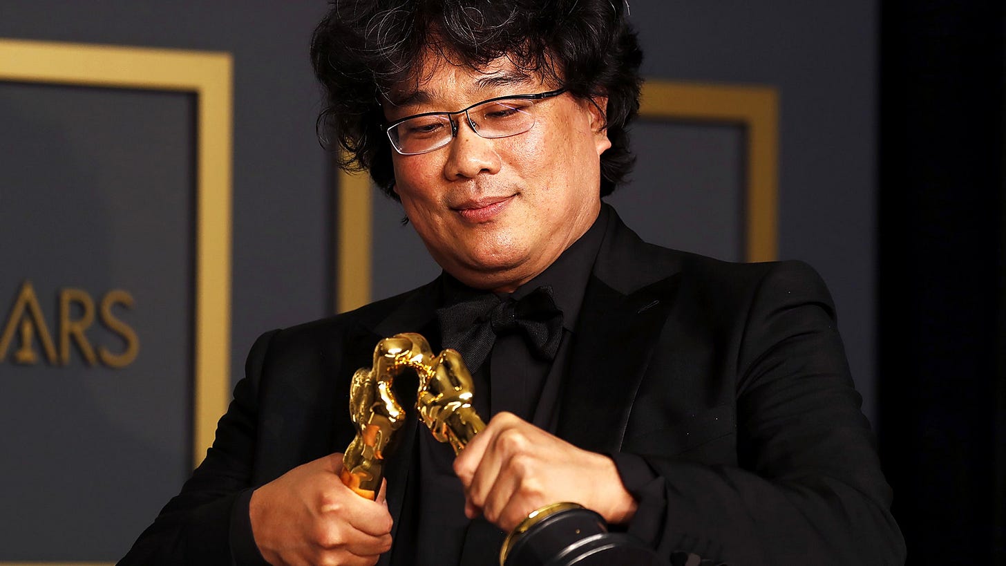 Director Bong Joon Ho posing with his Oscars making the two statuettes kiss Director Bong Joon Ho posing with his Oscars making the two statuettes kiss