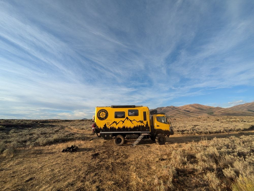 Walter the big, yellow truck, alone in the desert with a pretty blue sky streaked with thin clouds