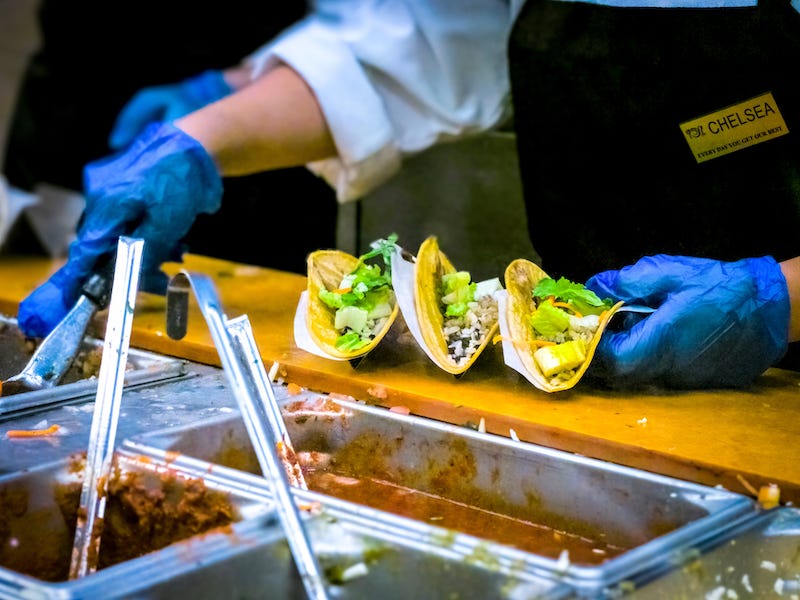 school cafeteria with worker filling taco shells