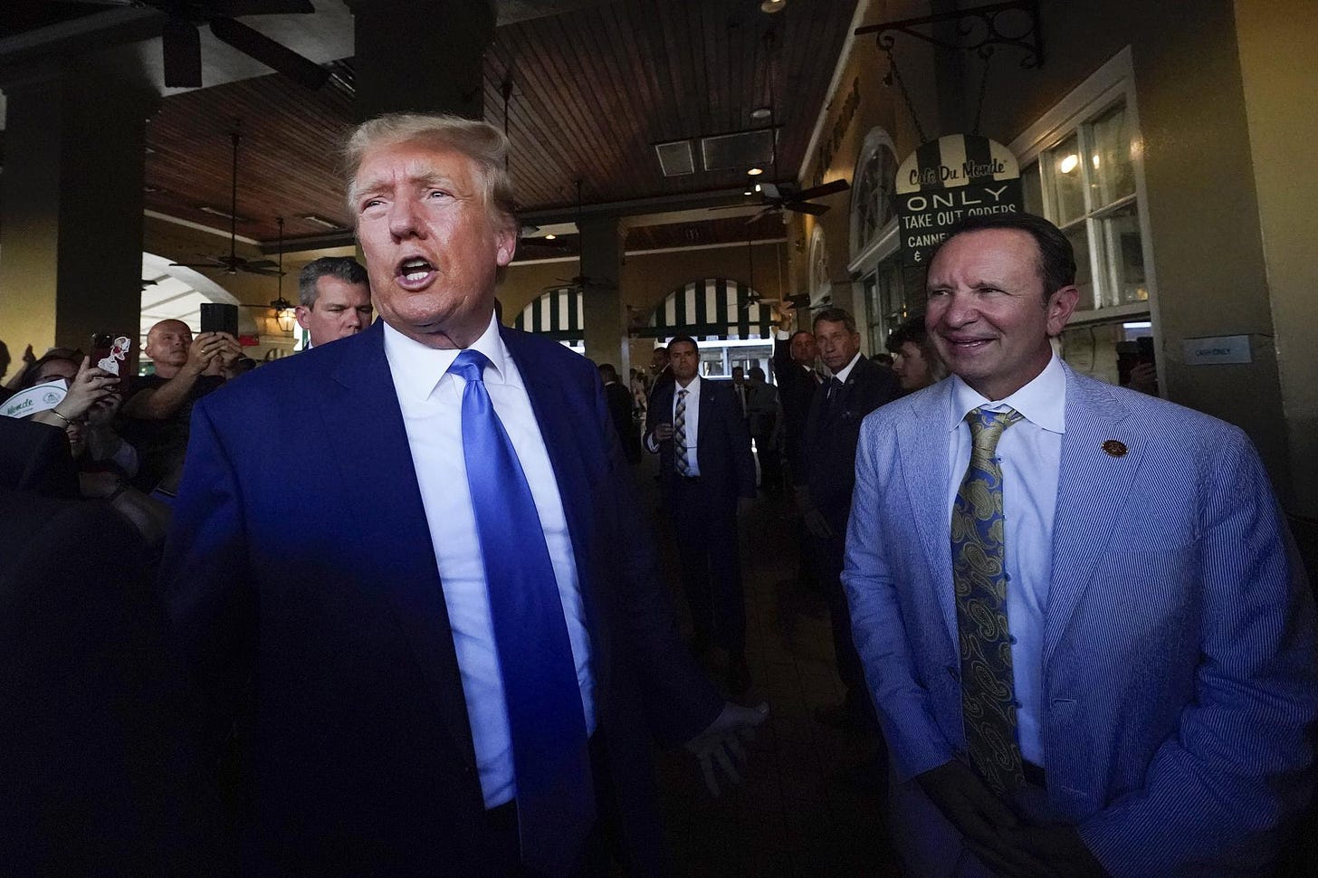 Donald Trump visits Café du Monde in New Orleans, accompanied by Louisiana Attorney General Jeff Landry, right.