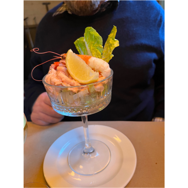A glass with shrimp and lemon on it

Description automatically generated