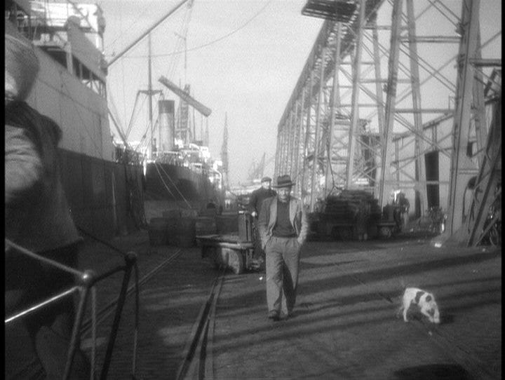 Jean Gabin stalks the quay at the harbour in Le Havre. Head down, hands in pockets