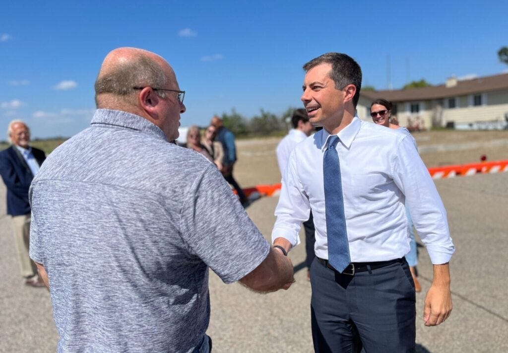 Chamberlain City Administrator Clint Soulek, left, shakes hands with U.S. Secretary of Transportation Pete Buttigieg on Sept. 11, 2023, at the Chamberlain Municipal Airport. (Joshua Haiar/South Dakota Searchlight)