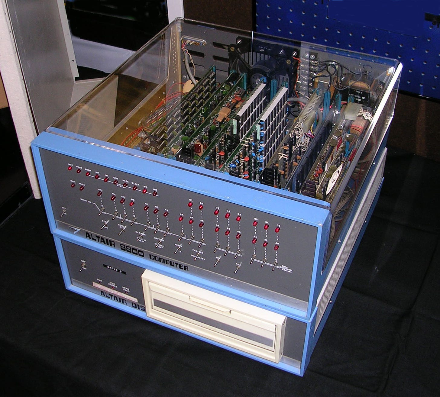 The Altair 8800, a boxy computer with red LEDs on the front and a cleear case exposing circuitry
