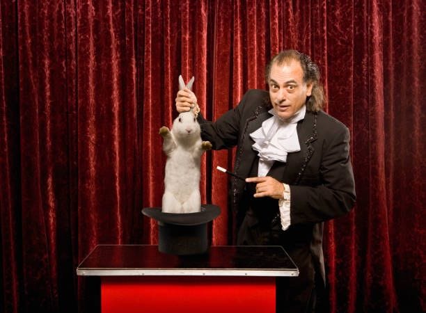 magician pulling a rabbit out of a hat - pull a rabbit out of the hat stock pictures, royalty-free photos & images