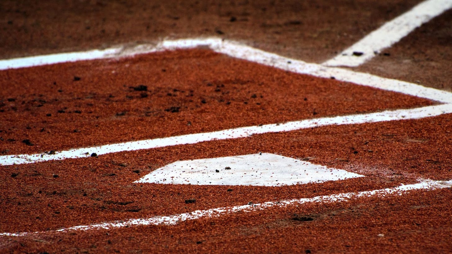 a home plate with chalked batters boxes surrounding it in the dirt. a home plate with chalked batters boxes surrounding it in the dirt.