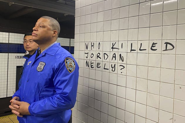 Police officers watch as protesters gather in the Broadway-Lafayette subway station to protest the death of Jordan Neely.