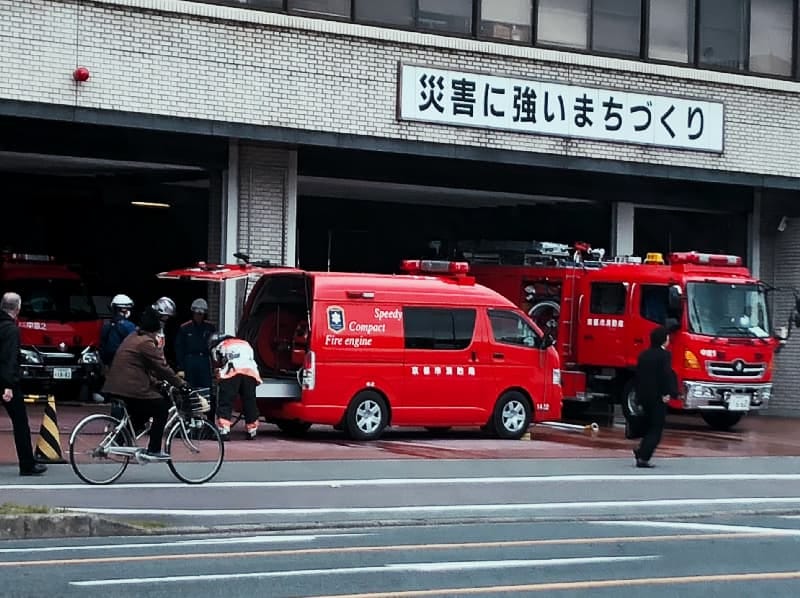 Photograph of fire engines at a Tokyo fire station, seen from across a nearly empty road Photograph of fire engines at a Tokyo fire station, seen from across a nearly empty road