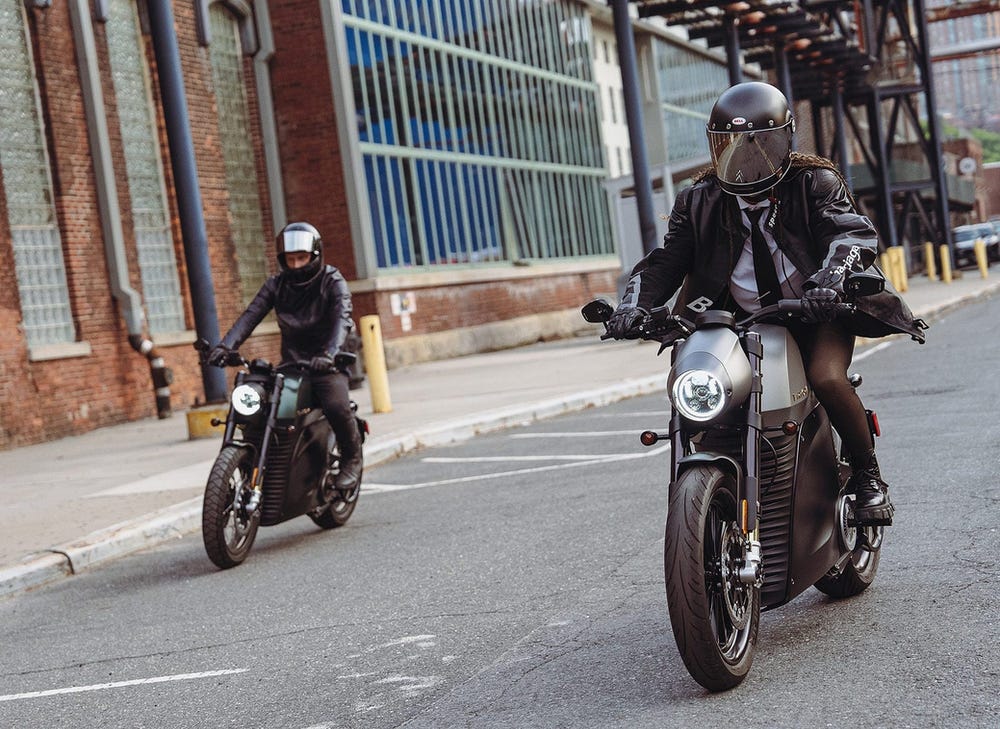 Two Luna electric motorcycle riders in an urban setting. 