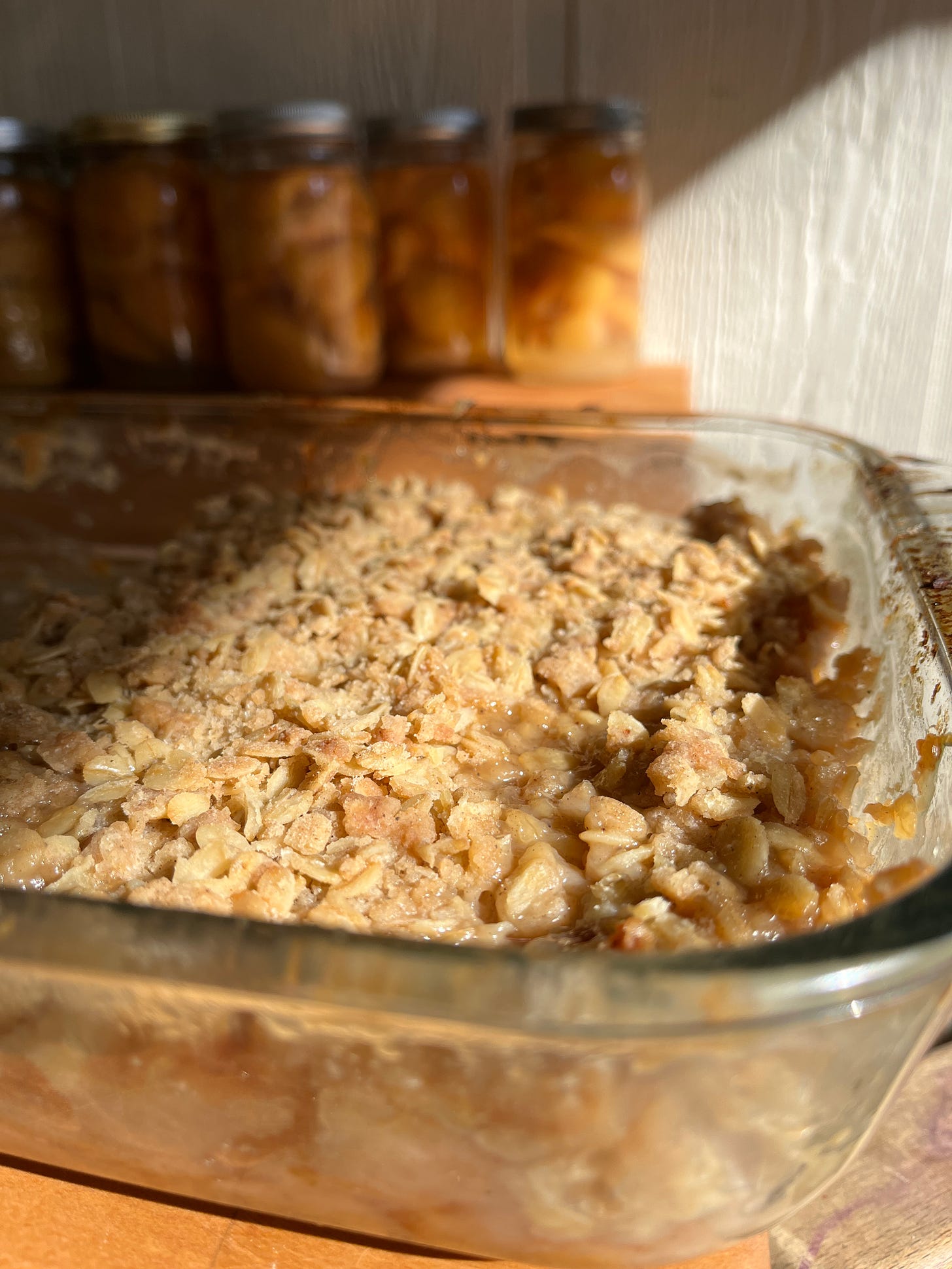 Pear crisp in glass pan; home canned pears in background