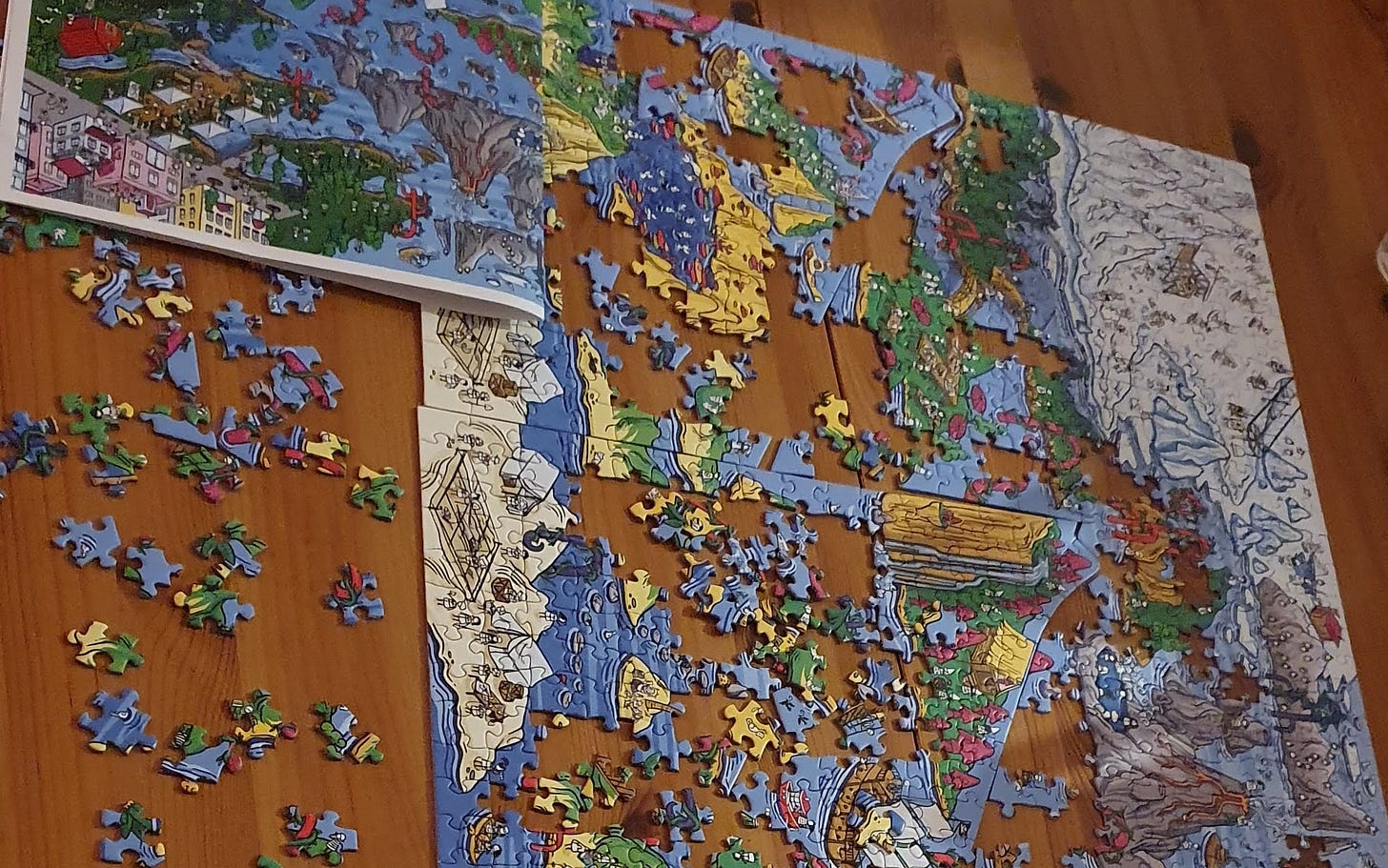 A close up of a puzzle half build on a table with some pieces on the side