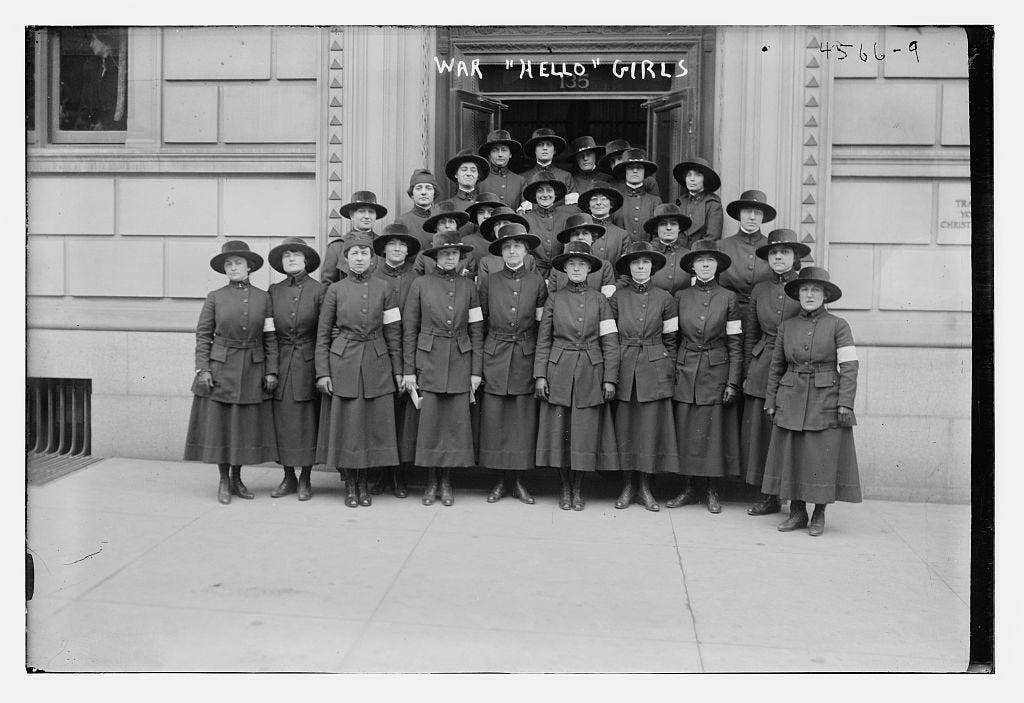 A fine bunch of women in a formal photo. The are wearing a dark uniform and are all wearing wide-brimmed hats and arm-bands.
