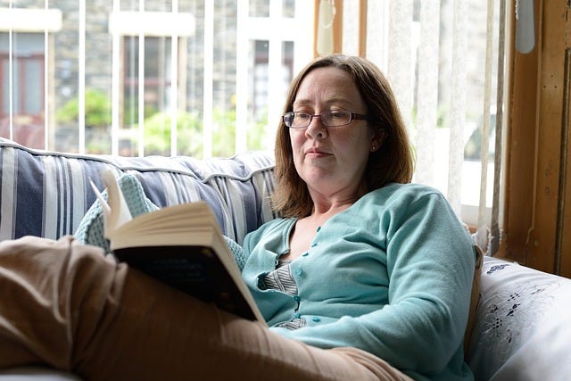 Woman on sofa reading book