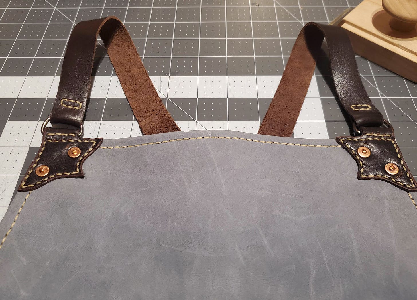 A shop apron with peened rivets at the corners.