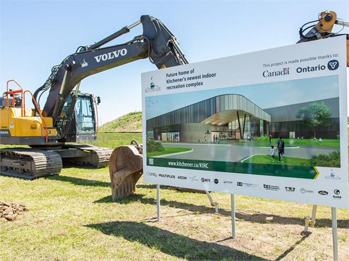 Large sign announcing the development with a large construction vehicle to the left.