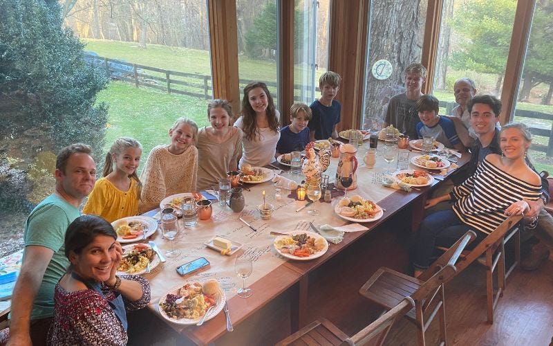 A big family sharing Thanksgiving dinner at a long table.