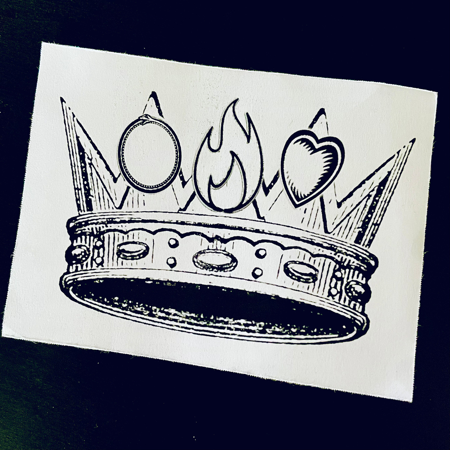 a crown with an ouroboros, flame, and heart on the pointed spikes.