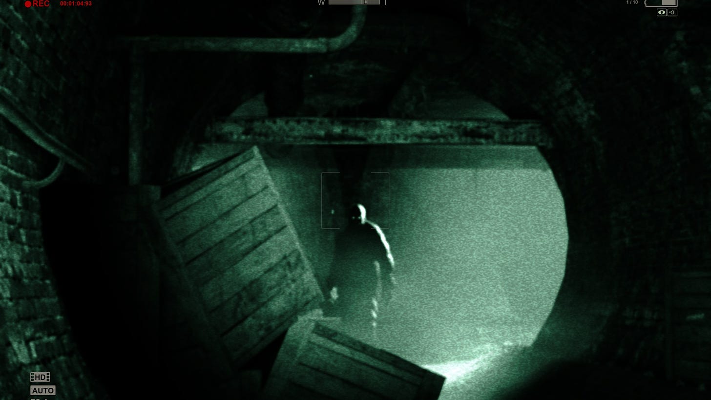 One of the "key art" screenshots of Outlast, showing a supporting character of muscular build standing in the distance looking at the player. The entire image is covered in a night vision filter, making the entire thing an eerie green. The character's eyes light up in the darkness.
